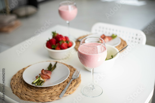 a healthy meal of asparagus and a strawberry smoothie