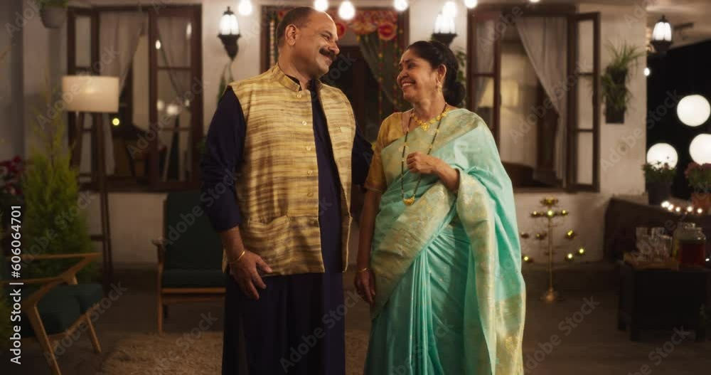 Portrait of Happy Indian Middle-aged Couple in Traditional Clothes Posing Together at Their Authentic Mumbai Home. Husband and Wife Celebrating Diwali, Looking at the Camera. Slow Motion Zoom In Portrait of Happy Indian Middle-aged Couple in Traditional Clothes Posing Together at Their Authentic Mumbai Home. Husband and Wife Celebrating Diwali, Looking at the Camera. Slow Motion Zoom In