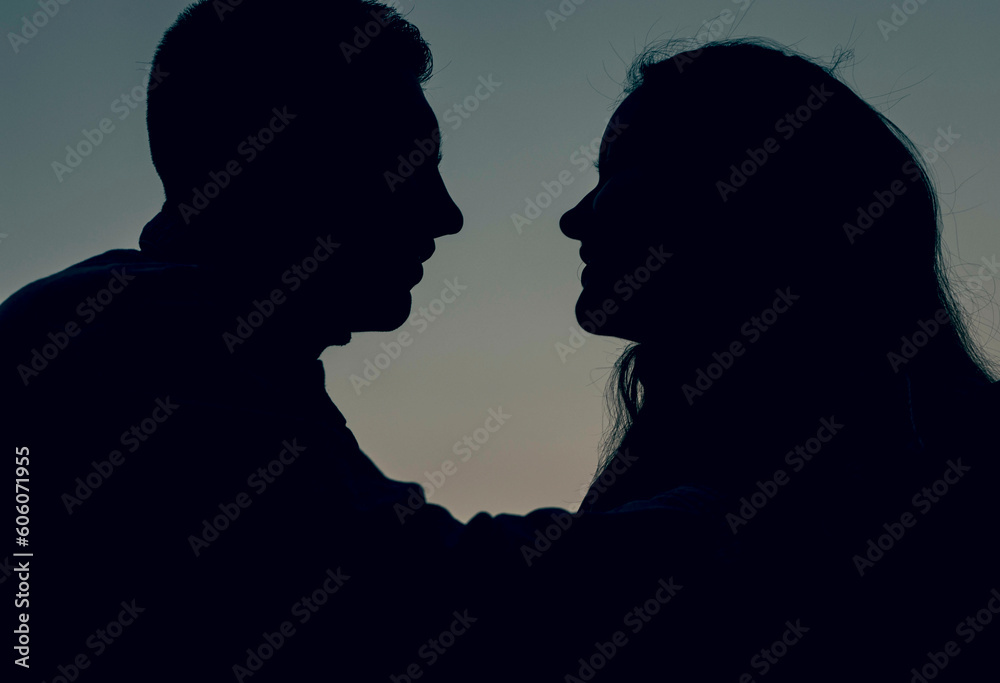 Silhouettes sensual young couple in love posing at the sunset, happy lifestyle concept