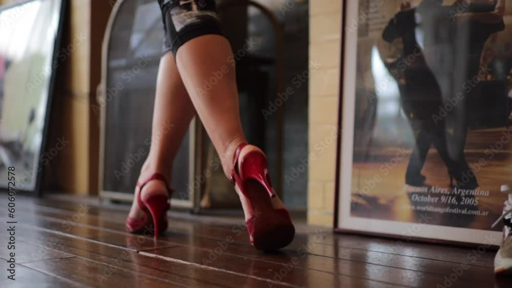 Mujer practicando tango sola en estudio de baile con zapatos de tacones altos Mujer practicando tango sola en estudio de baile con zapatos de tacones altos