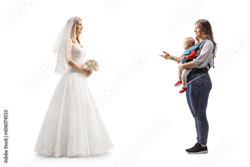 Full length profile shot of a bride and a mother with a baby having a conversation