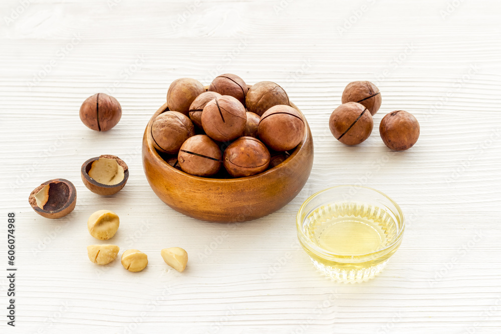 Bowl of of macadamia nuts oil with raw nuts. Natural oil for cosmetic or cooking Bowl of of macadamia nuts oil with raw nuts. Natural oil for cosmetic or cooking