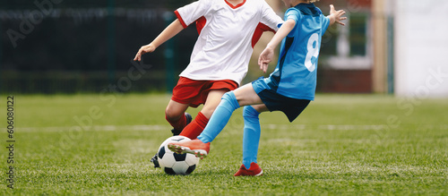 Two soccer players running and kicking a soccer ball. Legs of two young football players on a match. European football youth player legs in action. © matimix