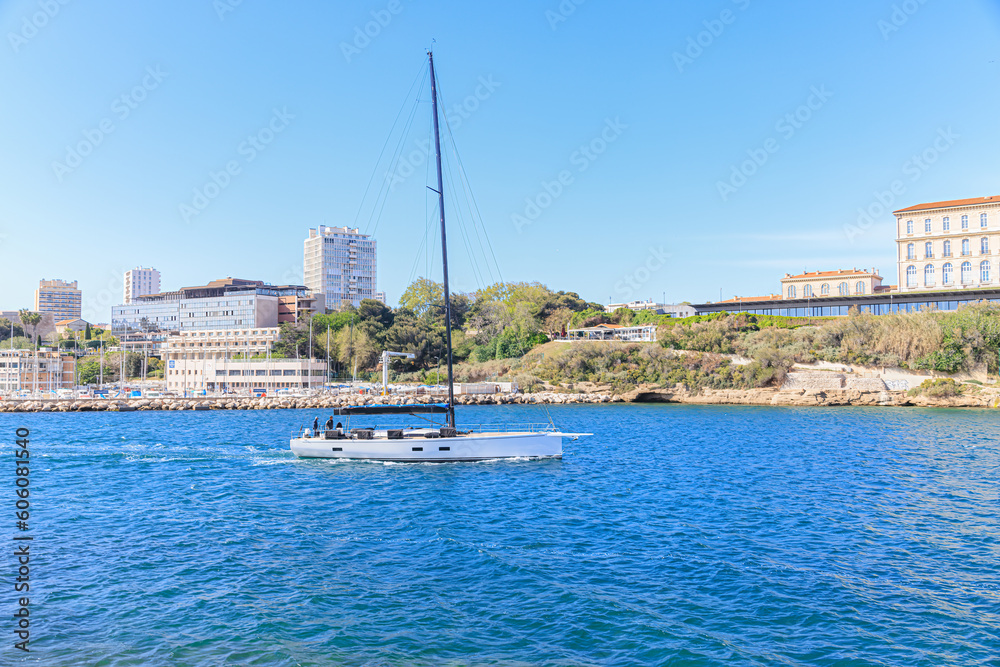 A scenic view of a sailboat leaving the port of Marseille, bouches-du-rhône, France under a majestic blue sky