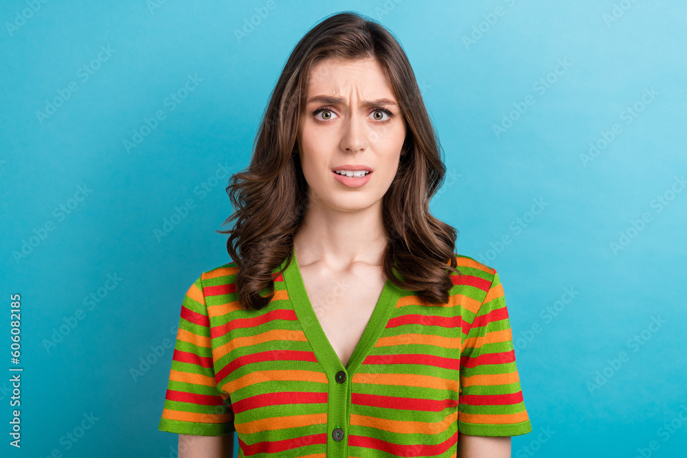 Fototapeta premium Portrait of dissatisfied gorgeous woman with wavy hairdo dressed colorful cardigan staring nervous isolated on blue color background