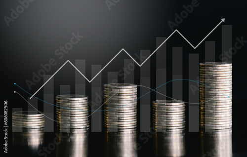 Stack of money coin on black background with graph and up arrow. Business and finance background concept.
