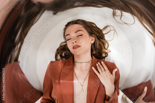 Фотография circular shot of young woman with brunette hair and closed eyes wearing blazer a