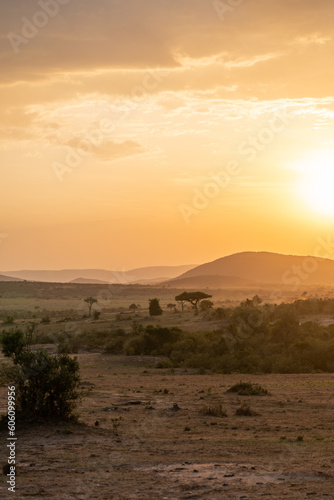 Iconic Africa sunset and orange sky with large sun, over the Masaai Mara Reserve in Kenya
