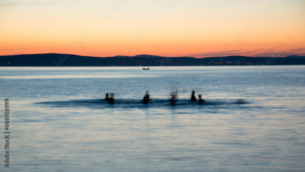 bathers in Lake Balaton at sunset