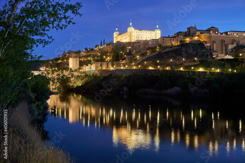 A mesmerizing panoramic view of Toledo at night, overlooking the Tajo River. The illuminated cityscape showcases the city's architectural marvels, creating a captivating and enchanting scene.