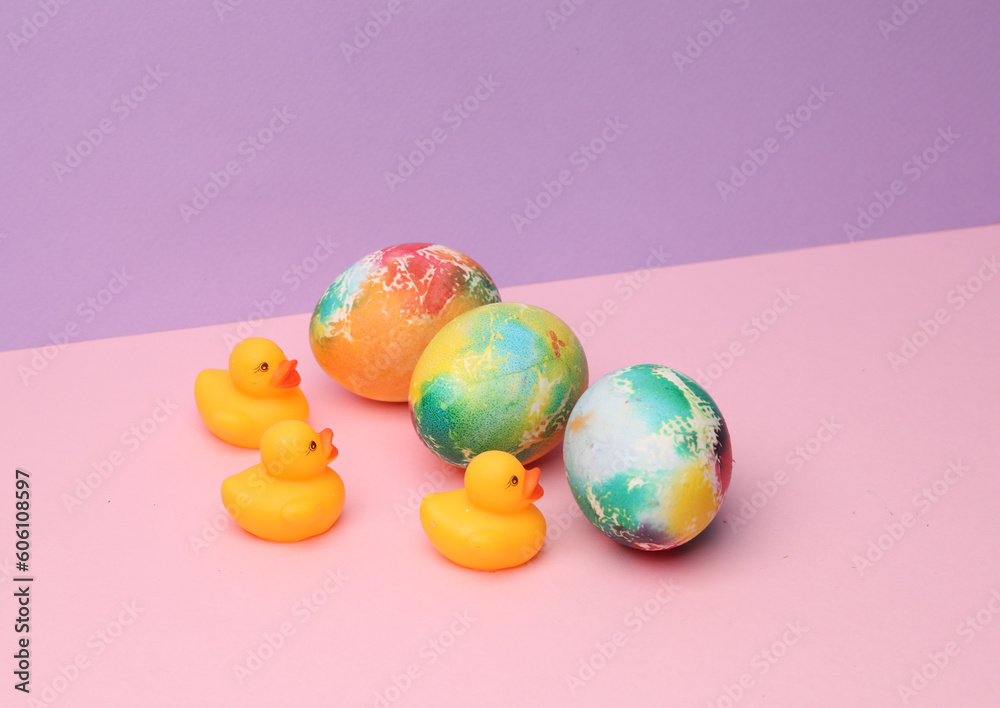 Easter colored eggs and rubber ducks on pastel color background. Minimalism Easter still life
