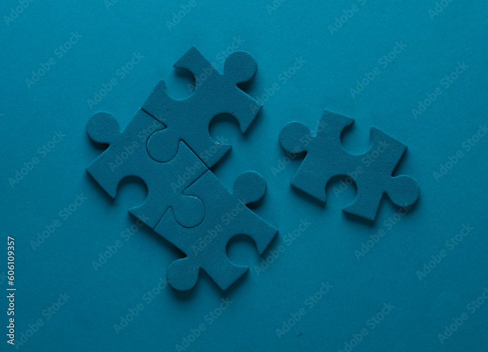 Blue jigsaw puzzle particles on blue background. Business concept Blue jigsaw puzzle particles on blue background. Business concept