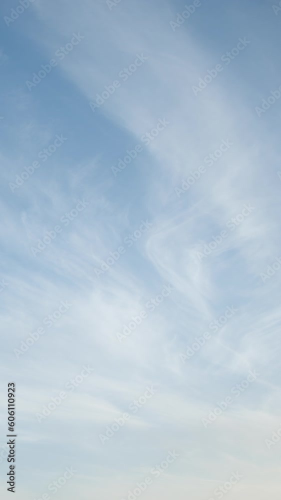 The sight of elongated cirrus clouds peacefully moving across the clear blue sky creates a serene scene of natural beauty. Video timelapse. Vertical video. The sight of elongated cirrus clouds peacefully moving across the clear blue sky creates a serene scene of natural beauty. Video timelapse. Vertical video.