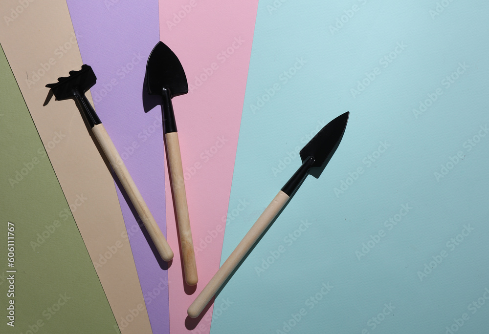 Set of miniature gardening tools on a pastel background Set of miniature gardening tools on a pastel background