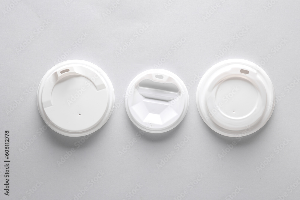 White plastic disposable lids for cup on gray white background. Mockup, template for design White plastic disposable lids for cup on gray white background. Mockup, template for design