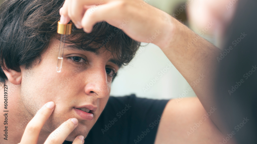 Naklejka premium Young man dripping serum on his face