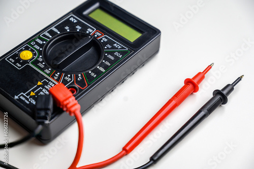 multimeter and test leads on a white table. A device for measuring current.