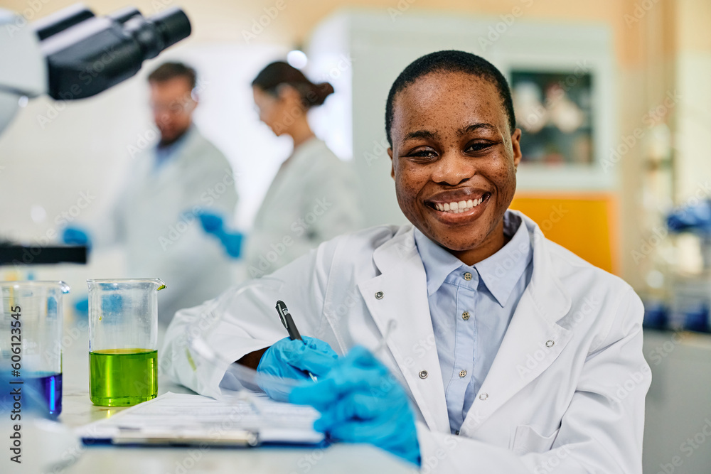 Happy African American female scientist in lab looking at camera. Happy African American female scientist in lab looking at camera.