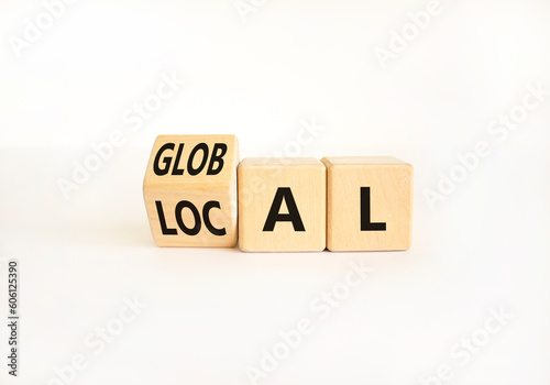 Local or global symbol. Businessman turns wooden cubes and changes the word Local to Global. Beautiful white table white background. Business and local or global concept. Copy space.