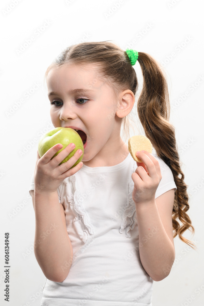 Green apple and potato chips, healthy and unhealthy food for kids, little girl chooses apple over chips. Green apple and potato chips, healthy and unhealthy food for kids, little girl chooses apple over chips.