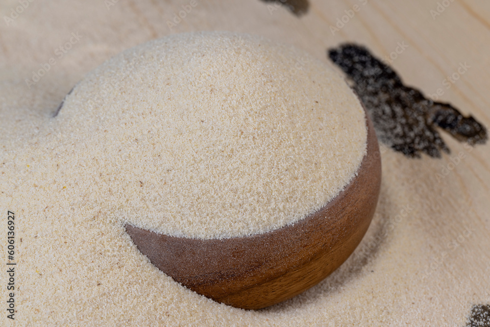 Obraz premium Semolina poured into a round wooden bowl ready for cooking