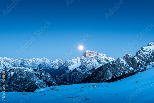il monte cristallo visto dalla torre toblin, illuminato dalla luna piena appena prima dell'alba photo