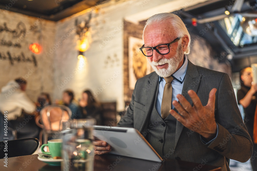 Senior man businessman business owner use digital tablet sit at cafe Senior man businessman business owner use digital tablet sit at cafe