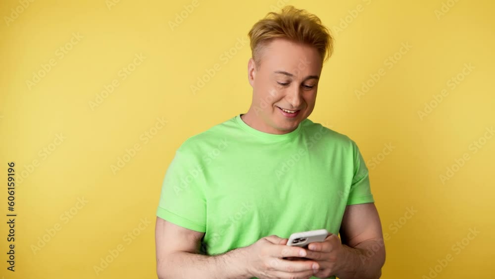 Man smiling, phone scroll, happiness and swiping on online dating app. Mobile smartphone chat wifi and happy guy male for social media and internet, studio shot isolated on yellow background Man smiling, phone scroll, happiness and swiping on online dating app. Mobile smartphone chat wifi and happy guy male for social media and internet, studio shot isolated on yellow background