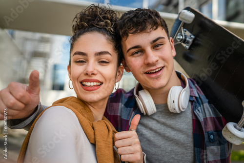 Young man and woman teenager couple take selfies by modern building