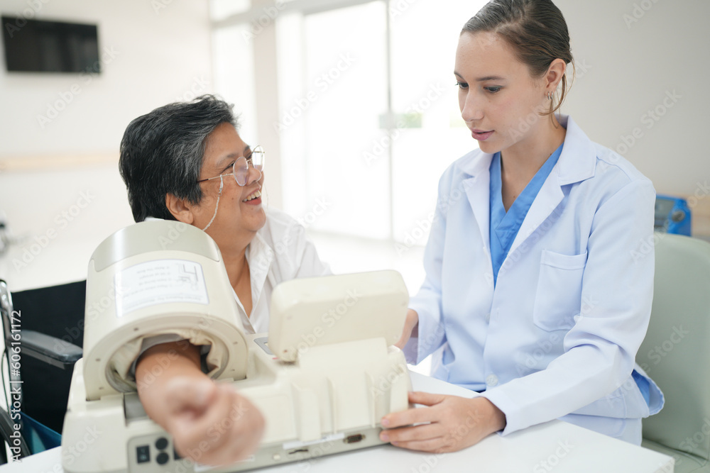 Fototapeta premium Female doctor doctor measuring senior female's blood pressure at medical clinic.