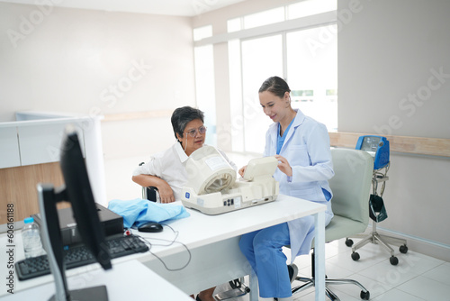 Female doctor doctor measuring senior female s blood pressure at medical clinic.