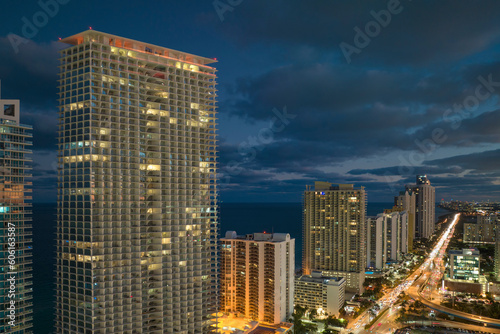 Night urban landscape of downtown district in Sunny Isles Beach city in Florida  USA. Skyline with brightly illuminated streets and high skyscraper buildings in modern american megapolis
