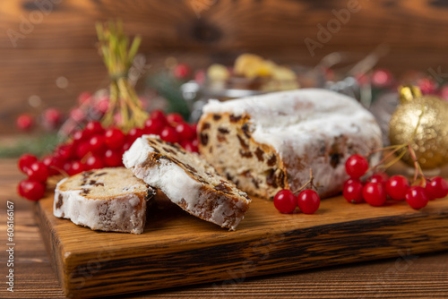 Christmas stollen on a texture table. Traditional German Christmas dessert cut into pieces. Cake with nuts, cinnamon, raisins, dried fruits and marzipan. baking for christmas. Place for text. 