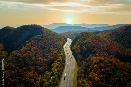 View from above of I-40 freeway route in North Carolina leading to Asheville thru Appalachian mountains with yellow fall woods and fast moving trucks and cars. Interstate transportation concept photo