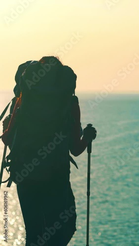 The man and woman with backpacks walking near the sea. slow motion