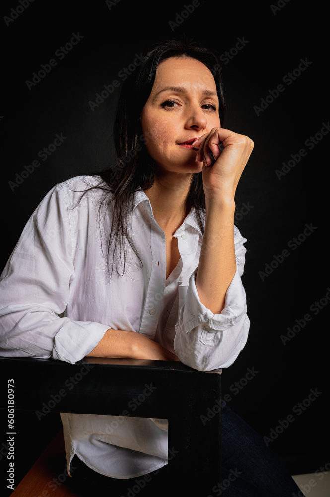 close-up business portrait of young beautiful girl, emotional smiling look, standing on dark background, looking to side, white shirt and men's jacket, studio shot with copy space close-up business portrait of young beautiful girl, emotional smiling look, standing on dark background, looking to side, white shirt and men's jacket, studio shot with copy space