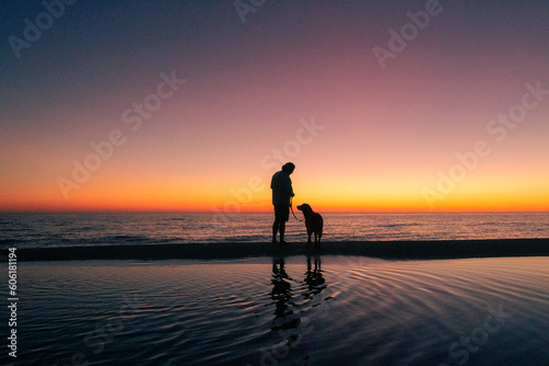 person and dog at sunset