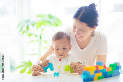 Baby boy  and mother playing with toy