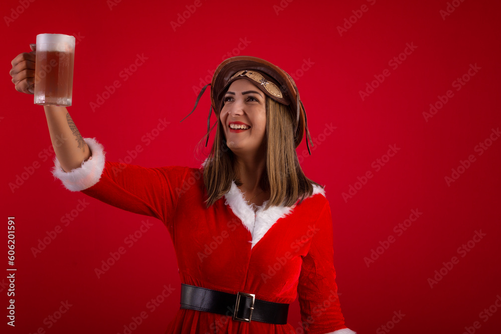 Very pretty adult woman holding a glass of beer, wearing a Santa Claus ...