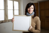 Portrait of a beautiful woman holding a blank board in the room