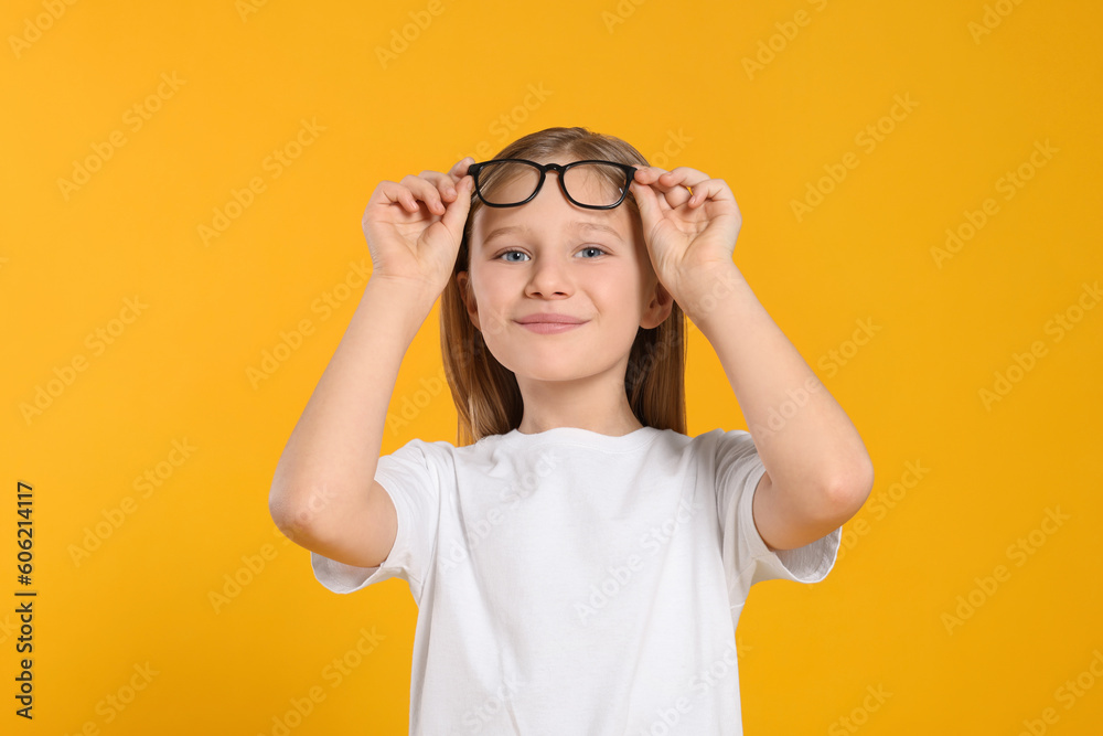 Portrait of cute girl with glasses on orange background Portrait of cute girl with glasses on orange background