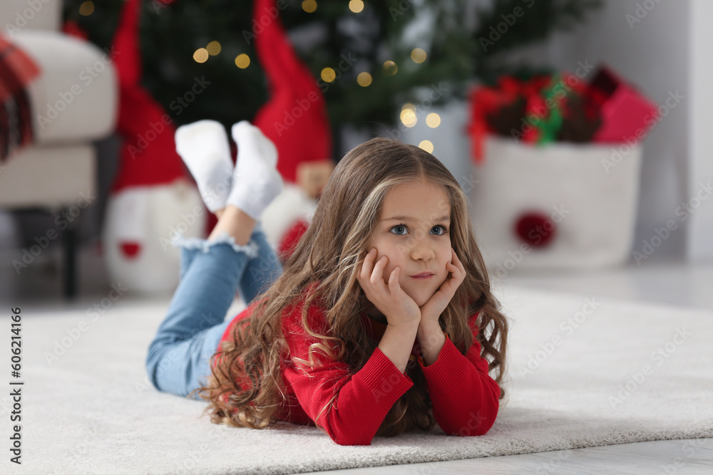 Little girl lying on soft carpet at home. Christmas atmosphere Little girl lying on soft carpet at home. Christmas atmosphere