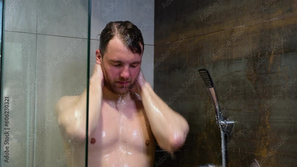Portrait Of Handsome Man Taking A Shower Washing Head Standing Under Falling Hot Water In Modern Bathroom At Hotel. Enjoying The Morning Portrait Of Handsome Man Taking A Shower Washing Head Standing Under Falling Hot Water In Modern Bathroom At Hotel. Enjoying The Morning