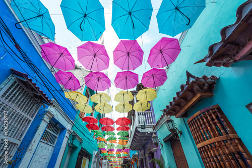 Cartagena, Bolivar, Colombia. March 15, 2023: Getsemani neighborhood Calle de la Magdalena decorated with colorful umbrellas and drawings. photo