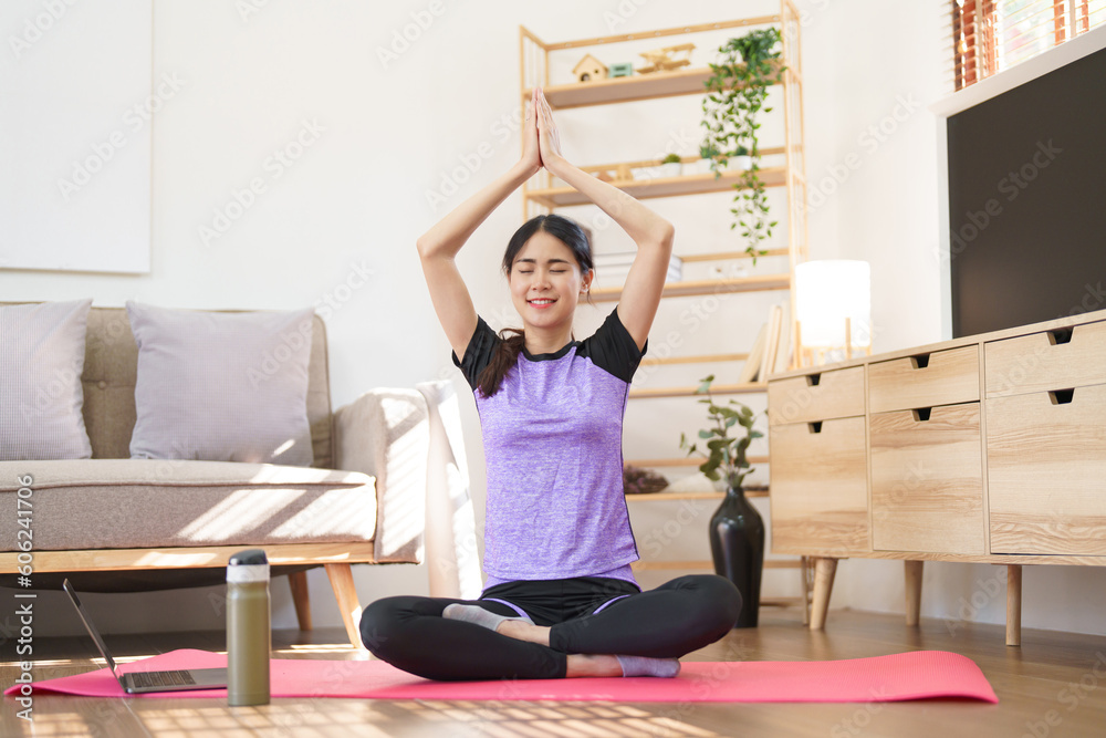 Sporty woman meditating to practice yoga exercise while raise hands to doing yoga with namaste pose