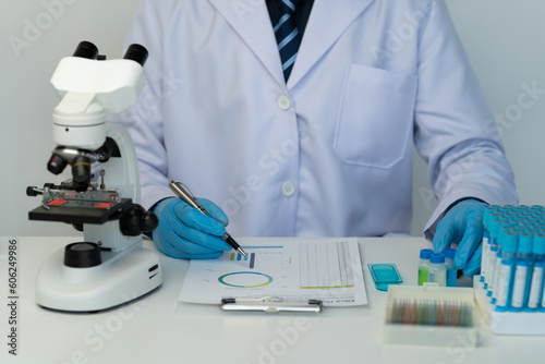 Cropped view of male scientist recording data using pill sampling tubes for analysis and testing, advanced science laboratory for medicine biotechnology development of microbiology.