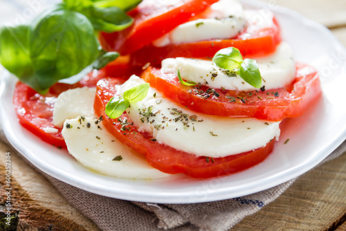 caprese salad white plate rustic wood background
