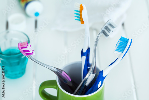 tooth brushes in glass on table