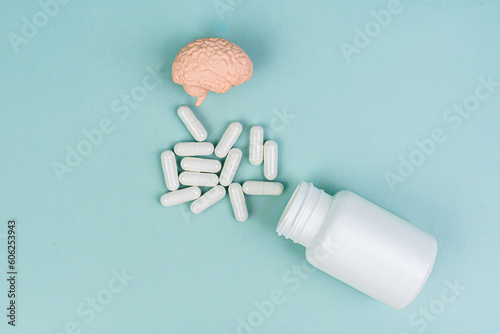 Vitamins for brain health. Brain on a blue background. Medicine, taking pills. Essential nutrients for brain health including vitamin C, vitamin B, folic acid, vitamin PP, pills. 