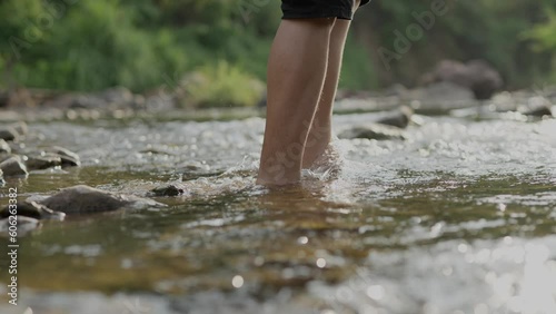 A boy wading in shallow water in the river